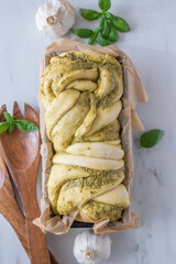 home made braided basil pesto bread on a table
