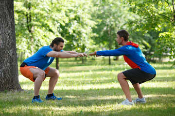 Obraz premium Two men warming up muscles before jogging.