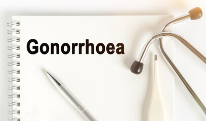 On the table are a stethoscope, a thermometer, a pen and a notebook with the inscription -Gonorrhoea