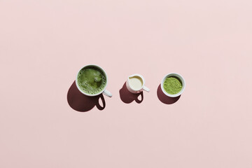 Vegan matcha latte with oat milk and ingredients on pink