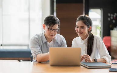 Obraz premium Asian business people man and woman conference talking and working with laptop together. Young couple work at home.