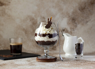 Chocolate trifle with whipped cream cheese in a glass, individual layered dessert
