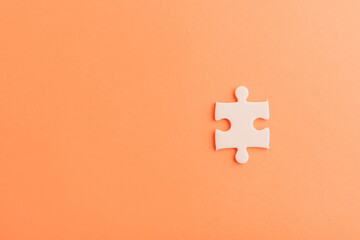 Top view flat lay of one paper plain white jigsaw puzzle game last pieces for solve, studio shot on an orange background, quiz calculation concept