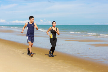 Asian runners fitness couple running training on beach, cardio workout .Active sports lifestyle concept
