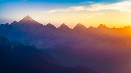 Naklejka na ściany i meble Mountain silhouette of Panchchuli peaks during morning sunrise in great Himalayan mountain chain range from Khalia Top at small hamlet Munsiyari, Kumaon region, Uttarakhand, India.