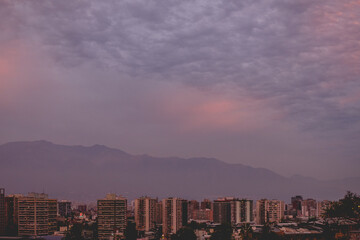 Obraz premium Amazing dramatic cloudy sunset sky over Santiago downtown and Los Andes mountains, Chile