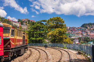 Toy train Kalka-Shimla route, standing on Shimla railway station with city in background. Shimla is state capital & tourist holiday destintation in the hill state Himachal Pradesh, India.