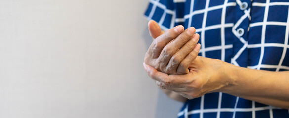 close up senior woman massage on hand to relief pain from hard working for treatment about carpal...
