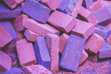 Clay handmade bricks. Pile of bricks abstract background. Bright pink-purple colored