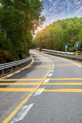 Empty curved road under sky and clouds