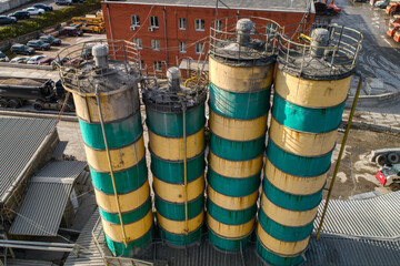 Cement storage silos are painted in yellow-green stripes.