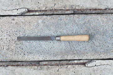 metal hand file with old wooden handle on concrete background