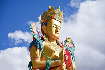 Closeup giant Maitreya Buddha statue with blue sky with clouds in Nubra Valley, Ladakh, Northern India.