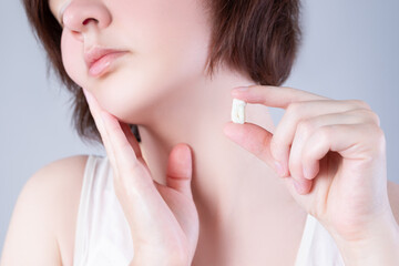 Wisdom tooth extraction, woman suffering from a toothache on gray background