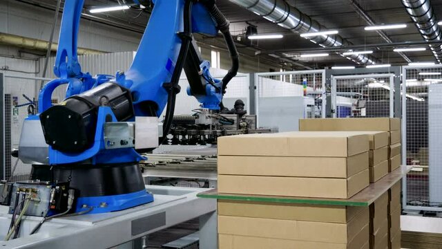 Furniture factory. A modern automated machine packaging furniture parts in cardboard boxes. 4K