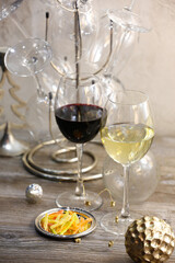 Glasses with red and white wine and snacks on a gray background