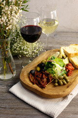 Glasses with red and white wine and snacks on a gray background