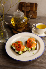 Sandwiches with salmon and egg with green tea on a gray background