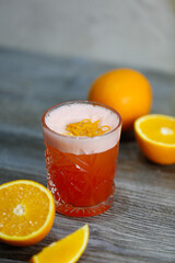 Bacardi cocktail with orange and orange zest on a gray background