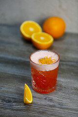Bacardi cocktail with orange and orange zest on a gray background