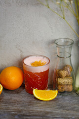 Bacardi cocktail with orange and orange zest on a gray background