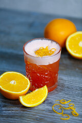Bacardi cocktail with orange and orange zest on a gray background