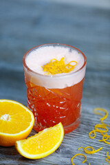 Bacardi cocktail with orange and orange zest on a gray background