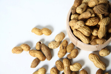 wooden bowl of peanuts on white background flat lay