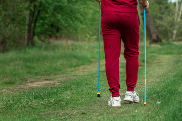 Nordic walking, sticks, legs close-up. The concept of a healthy lifestyle, cardio training. Copyspace.