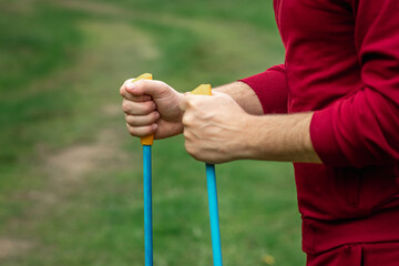 Nordic walking, sticks, hands close-up. The concept of a healthy lifestyle, cardio training. Copyspace.