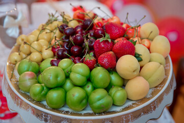 Strawberries, cherries, peaches, white cherries, cherries. Fruits in a plate.
