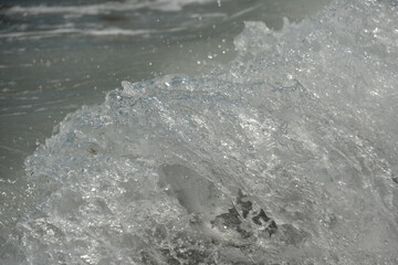 average waves on the sea reach the shore with foam and crash on the rocks with a noise