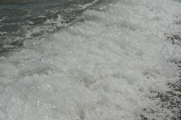 average waves on the sea reach the shore with foam and crash on the rocks with a noise