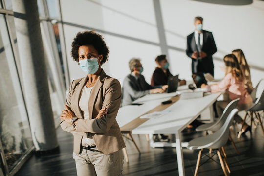 African American woman standing in office and wear mask as protection from corona virus