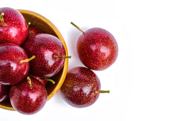 Closeup passion fruits ( Maracuya ) in wooden bowl isolated on white background . Top view. Flat lay.