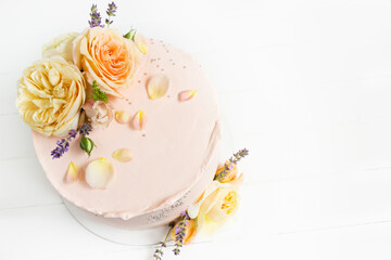 Fototapeta na wymiar Beautiful roses cake on wooden board Peach roses and lavender cake, Concept for Wedding , St. Valentine's Day, Mother's Day, Birthday Cake. White background