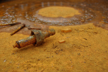 Rust, rusty bolts, nuts and screws, lie on a barrel.