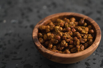 dried seaberry buckthorn in olive bowl on terrazzo countertop with copy space