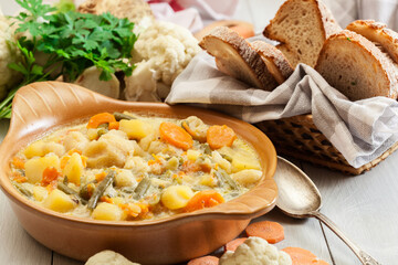 Vegetable soup with ingredients carrot, cauliflower, potato and parsley