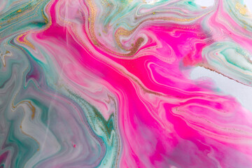 Obraz premium Pink, gold and green mixed inks spilled on white paper background. Golden glitter texture.