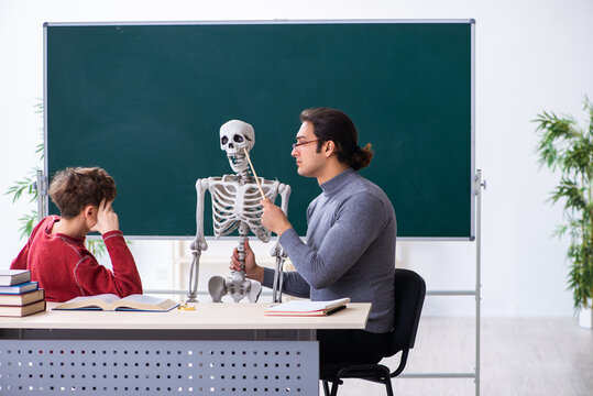 Young male teacher and schoolboy in the classroom
