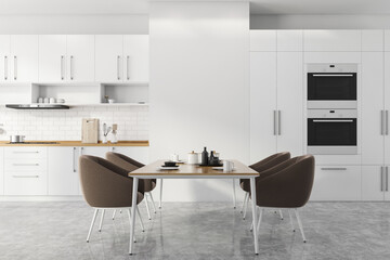 White kitchen with table and brown armchairs