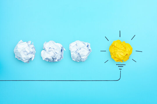 Creative idea, Inspiration, New idea, solution and Innovation concept with Crumpled yellow paper light bulb on blue background.