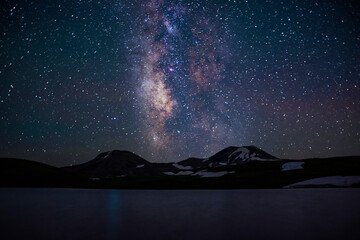 view of two mountains and milky way stars between them