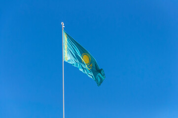 Kazakhstan flag waving in the wind at clear blue sky background