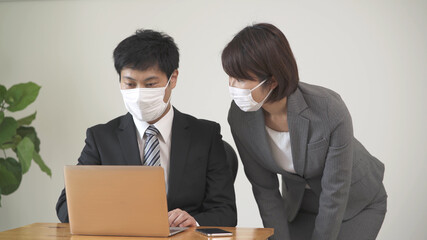 マスク姿のビジネスマンとビジネスウーマン