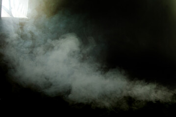 White smoke on a black background. The texture of scattered smoke in the studio. Blank for design. Layout for collages. The flash with the softbox illuminates the smoke machine.
