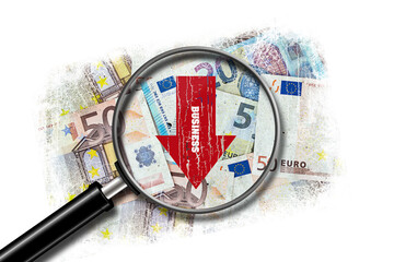 Business fall concept. Red down arrow on a background of Euro bills. View through a magnifying...