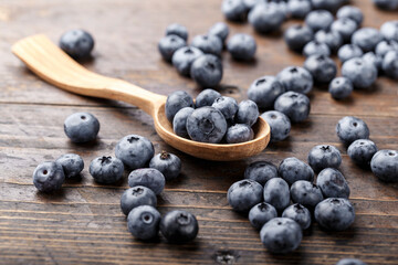 Blueberries in a wooden spoon  on a wooden  table.
