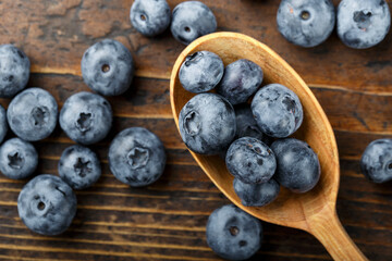 Blueberries in a wooden spoon  on a wooden  table.